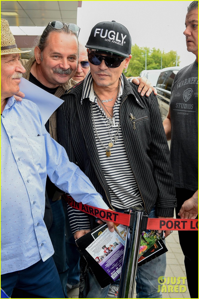 johnny-depp-greets-fans-while-arriving-at-poland-airport-06.jpg